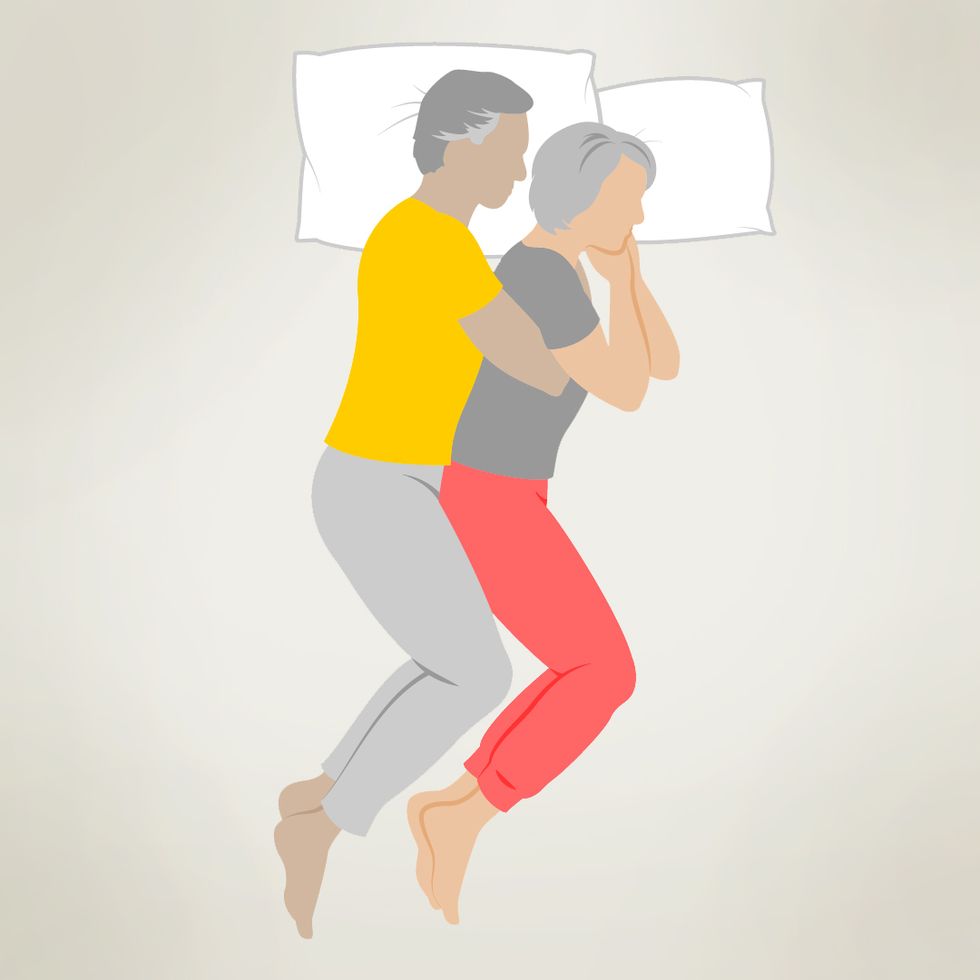 An illustration of a couple cuddling in the spooning position. The person in the yellow shirt is positioned behind the person in the gray shirt, with their arm draped over the person's side. Both individuals appear relaxed and comfortable, lying close together with their heads resting on pillows.